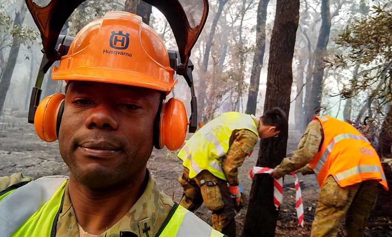 Army chaplain Fr Kene Onwukwe helping with the recovery effort after devastating bushfires on the NSW South Coast in 2020. Photo: Supplied