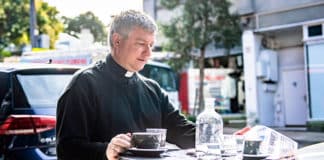 Precious down time: Fr Stephen Hill, a former Anglican who is a busy priest of the Ordinariate of Our Lady of the Southern Cross, enjoys a coffee and catching up on the news at a local cafe in Newtown. Currently engaged in building up the unique parish, he invites anyone interested to come and be part of it. Photo: Alphonsus Fok