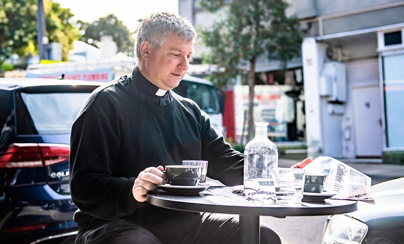 Precious down time: Fr Stephen Hill, a former Anglican who is a busy priest of the Ordinariate of Our Lady of the Southern Cross, enjoys a coffee and catching up on the news at a local cafe in Newtown. Currently engaged in building up the unique parish, he invites anyone interested to come and be part of it. Photo: Alphonsus Fok
