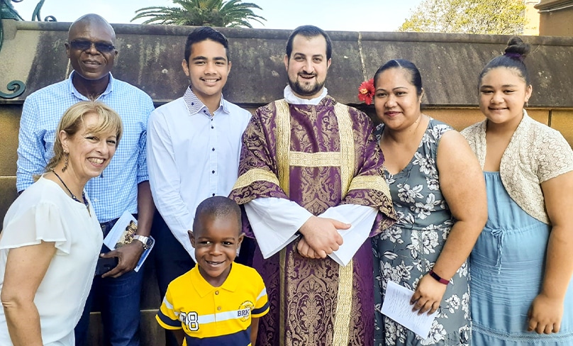 Tamburai Enoch Mutawemba, at left, with his son Joshua, Fr Roberto Keryakos and parishioners from All Saints Liverpool. Photo supplied