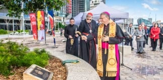 Watched by Cardinal George Pell and Father Lewi Barakat, Archbishop Anthony Fisher OP blesses the plaque commemorating the visit of Pope Benedict XVI to Sydney in 2008 for World Youth Day. The plaque is located at Barangaroo, where the pope disembarked and was welcomed by hundreds of thousands of pilgrims from Australia and around the world. Photo: Giovanni Portelli