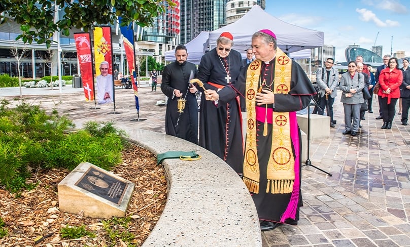 Watched by Cardinal George Pell and Father Lewi Barakat, Archbishop Anthony Fisher OP blesses the plaque commemorating the visit of Pope Benedict XVI to Sydney in 2008 for World Youth Day. The plaque is located at Barangaroo, where the pope disembarked and was welcomed by hundreds of thousands of pilgrims from Australia and around the world. Photo: Giovanni Portelli