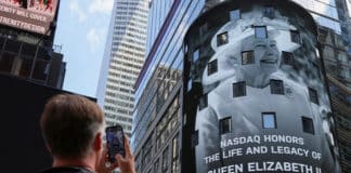A person takes photos as a tribute to Queen Elizabeth II appears on the screen of the Nasdaq MarketSite billboard in New York Sept. 8, 2022, after Britain's longest-reigning monarch and the nation's figurehead for seven decades died at the age of 96. Photo: CNS photo/Andrew Kelly, Reuters