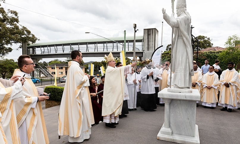 Watched by Fr Greg Skulski SDS and other clergy, Bishop Anthony Randazzo of the Diocese of Broken Bay blesses the new statue of St John Paul II outside St Patrick’s Church in East Gosford last weekend.  Photo: Courtesy of the Diocese of Broken Bay