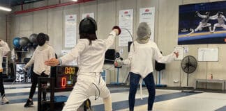 Megan Lam, left, lunges at her opponent in the NSW Fencing Centre. Photo: Supplied