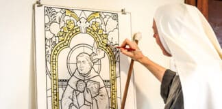 Sr Josephine, a Mary Morning Star Sister, paints her design of St Thomas Aquinas used in the skylight at Campion College. Photo: Supplied