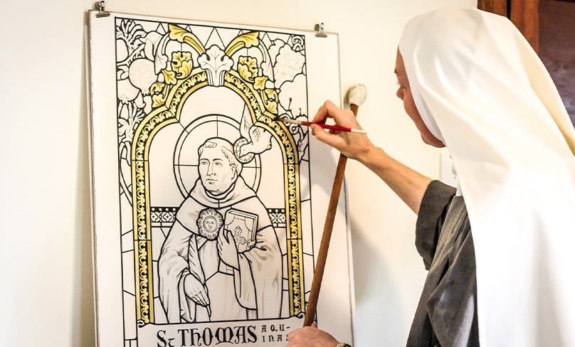 Sr Josephine, a Mary Morning Star Sister,  paints her design of St Thomas Aquinas used in the skylight at Campion College. Photo: Supplied