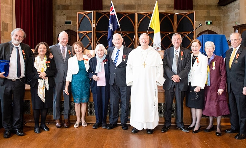 Archbishop Anthony Fisher OP joins the newly created knights, dames and one holder of the Papal Cross. They are, left to right, Toto and Rita Piccolo, doctors John and Julie James, Imelda and John O’Neill, John Carroll, Christine McNamee Liddy AO, Sr Elizabeth Delaney SGS and Paul Zammit OAM. Photo: Giovanni Portelli