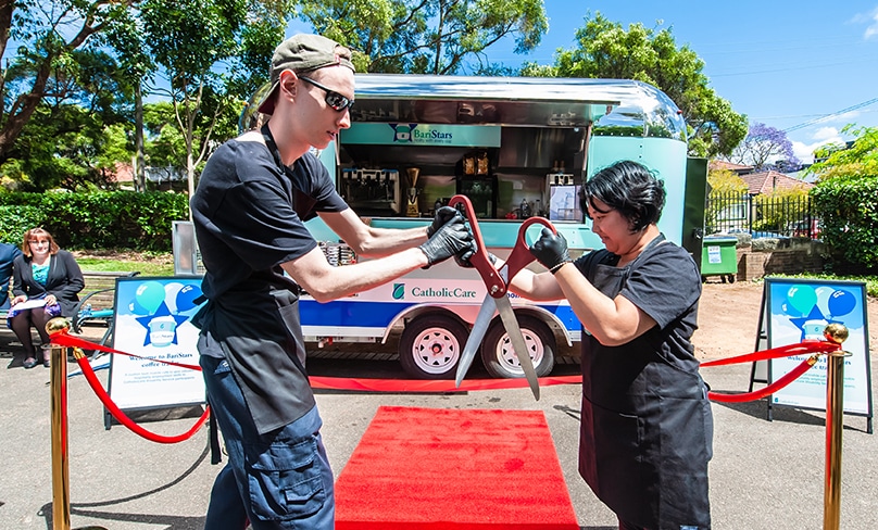 Fellow worker Tom helps Thuy, at right, cut the ribbon and officially open the new BariStars mobile coffee van. Photo: Giovanni Portelli