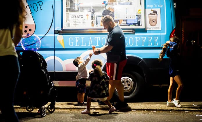 A man buys a child a gelato from one of the many vendors who turn up to Our Lady of Fatima Church grounds each month. Photo: Giovanni Portelli