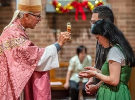 Bishop Daniel Meagher blesses a couple with a relic of St Gerard Majella, the patron saint of mothers, at St Paul of the Cross in Dulwich Hill. Photo: Giovanni Portelli