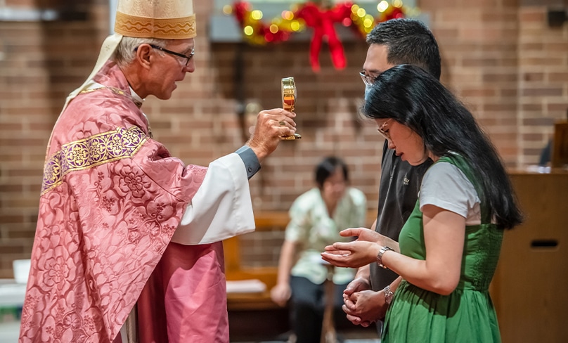 Bishop Daniel Meagher blesses a couple with a relic of St Gerard Majella, the patron saint of mothers, at St Paul of the Cross in Dulwich Hill. Photo: Giovanni Portelli 