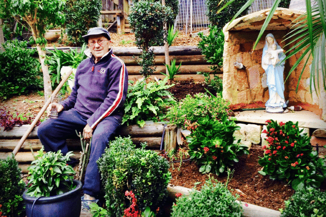 Tannous Daher, 83, in his garden. He was killed in the front yard of his brother-in-law’s Merrylands home by a driver under the influence of legal drugs. Inset, Tom Daher speaking at the launch of the Road Trauma Support Group NSW at NSW Parliament House on 21 November. PHOTO: Screenshot/Supplied