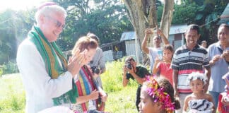 Bishop Richard Umbers is welcomed by villagers to Maliana. In the deeply devout society of Timor-Leste, a visit from a bishop is a standout event. Photo: Nicole Chehine