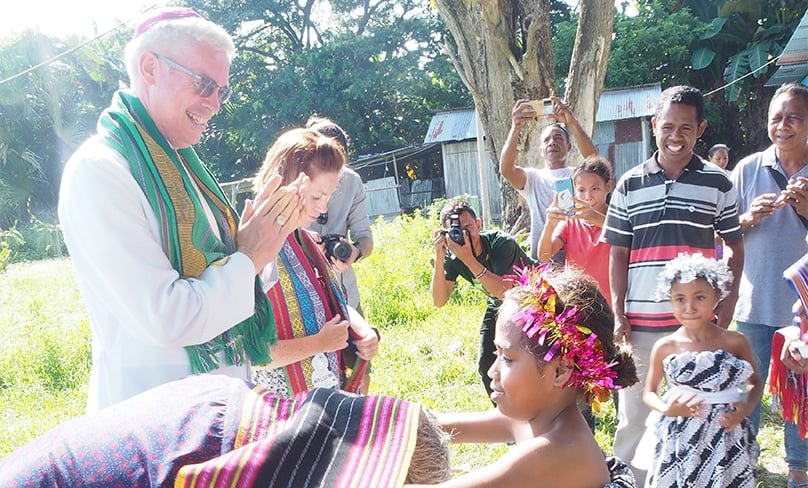 Bishop Richard Umbers is welcomed by villagers to Maliana. In the deeply devout society of Timor-Leste, a visit from a bishop is a standout event. Photo: Nicole Chehine