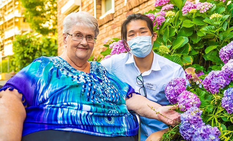 Joshua Wan, with one of his favourite residents, Pat, has won an international award for his book on living with the elderly as part of the Scalabrini community. Photo: Giovanni Portelli