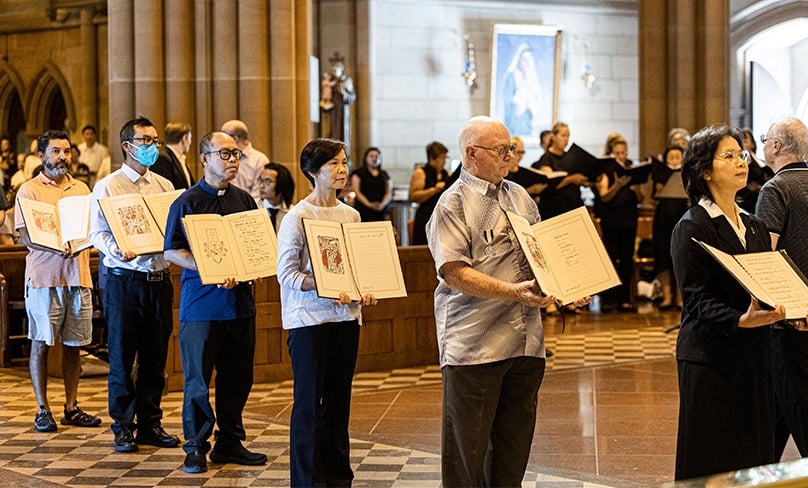 Parish representatives step forward with their books of the Elect, carrying the names of those who will become Catholics at Easter. Photo: Alphonsus Fok