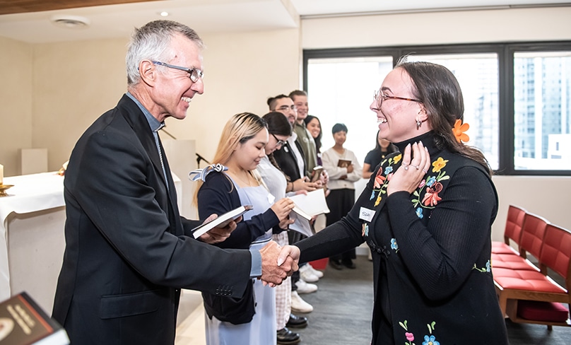 Bishop Daniel Meagher presents a copy of The Catechism of the Catholic Church and the Craft of Catechesis to the newly commissioned catechists at the Polding Centre on 21 March. Photo: Giovanni Portelli