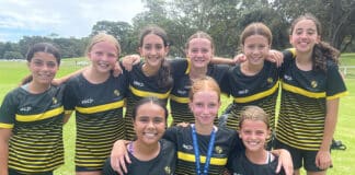 Marli Mayne, pictured bottom middle wearing her medal, with her Corpus Christi girls team who she led to a crucial victory against the ladder-leading St Clare’s Waverley. Photo: Supplied