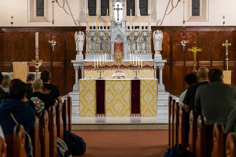 Hundreds of men kneel before the Blessed Sacrament at St Benedict's church in Broadway during an overnight pilgrimage from 28-29 April 2023.
