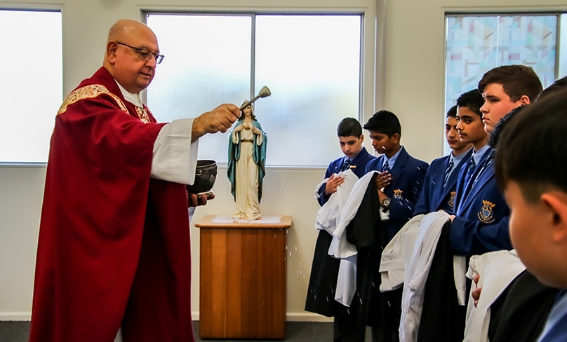 During the Mass, Fr Bob blessed the vestments which the students subsequently put on with the help of their family members and fellow servers. Photo: Patrician Brothers' College Senior Media Team