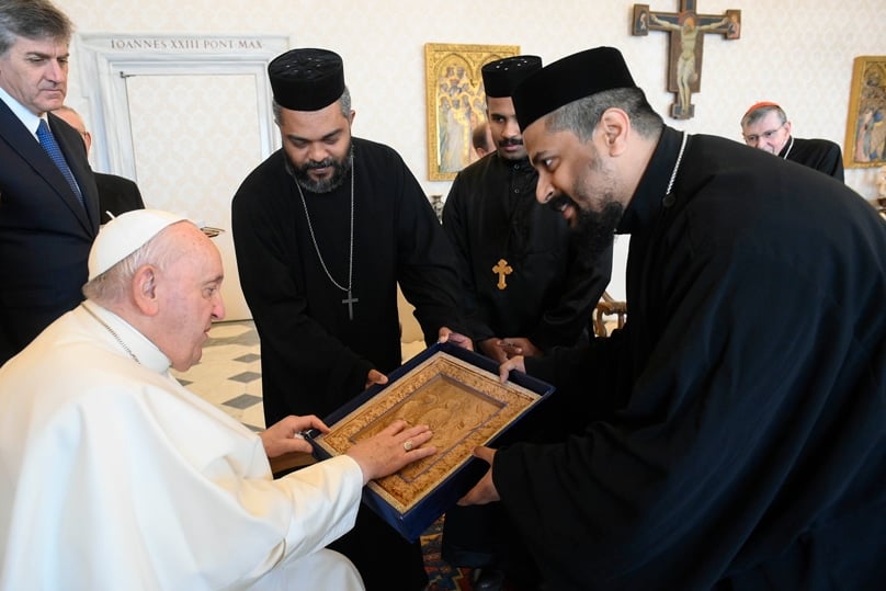 Pope Francis receives a gift during a meeting with young priests and monks representing the Coptic, Armenian, Syrian, Ethiopian, Eritrean and Syro-Malankara Orthodox churches in the library of the Apostolic Palace at the Vatican in February. Photo: CNS/Vatican Media