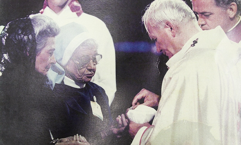 Cecilia Colreavy receives Communion from Pope John Paul II at the open-air Mass at Randwick Racecourse in 1986. Photo: Supplied