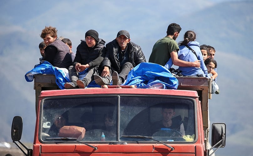 Refugees from the Nagorno-Karabakh region in Azerbaijan ride in a truck upon their arrival at the border village of Kornidzor, Armenia, in September. Photo: OSV News photo/Irakli Gedenidze, Reuters 