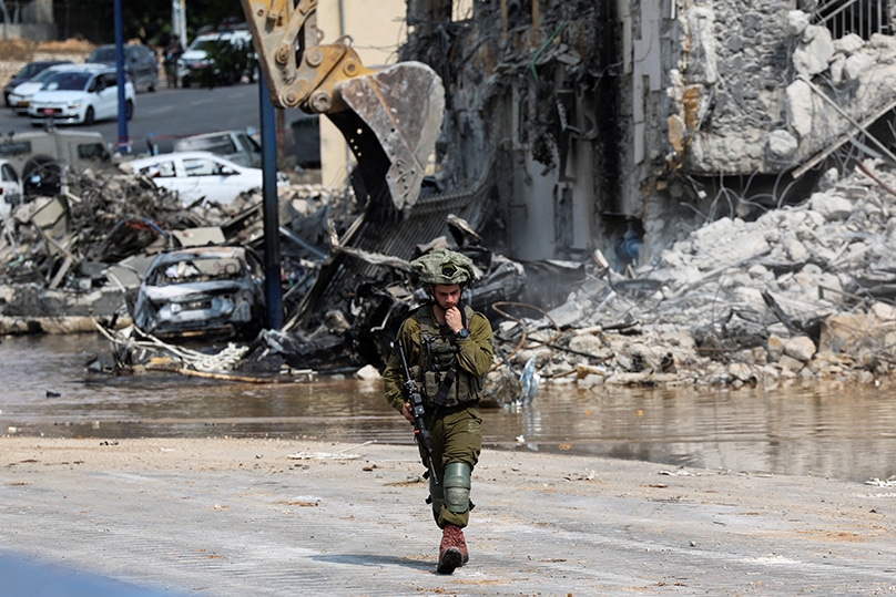 An Israeli soldier patrols near a police station in Sderot, Israel, 8 October 2023, which was destroyed following a mass infiltration by Hamas militants from the Gaza Strip. Photo: OSV News photo/Ronen Zvulun, Reuters