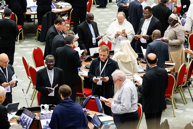 Members of the assembly of the Synod of Bishops pray before a working session in the Vatican's Paul VI Audience Hall on 26 October 2023. Photo: CNS photo/Lola Gomez