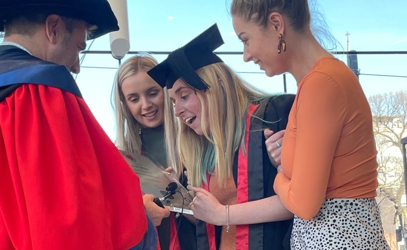 Watched by her parents and supported by her sisters Shai and Tyla, Jade left her wheelchair to receive her degree from Professor Justin Kemp, deputy dean of health sciences at ACU. Photo: Supplied