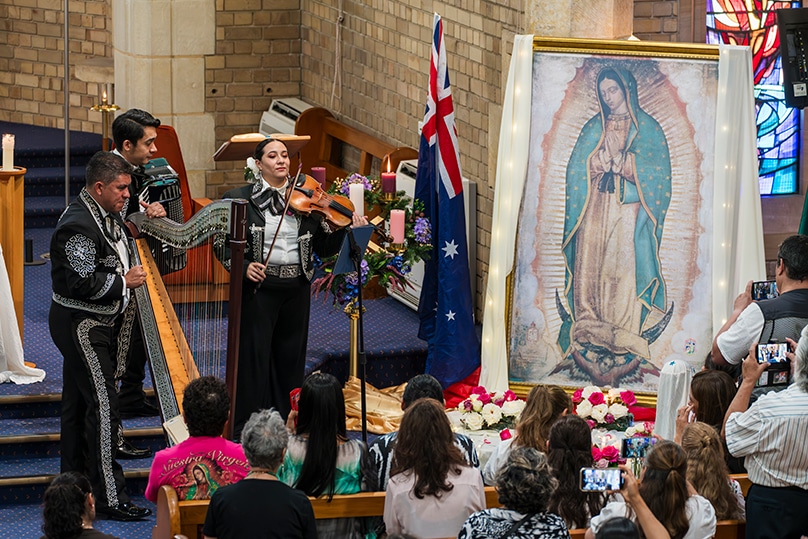 A Spanish-language Mass held at St Charles Borromeo church, Ryde, main. Parishioners gathering after Mass to share in the food and song, right. Photo: Patrick J Lee