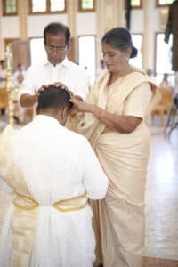 Fr Vinco’s parents Davies and Ruby Muriyadan pray over him prior to his ordination. Photo: Supplied