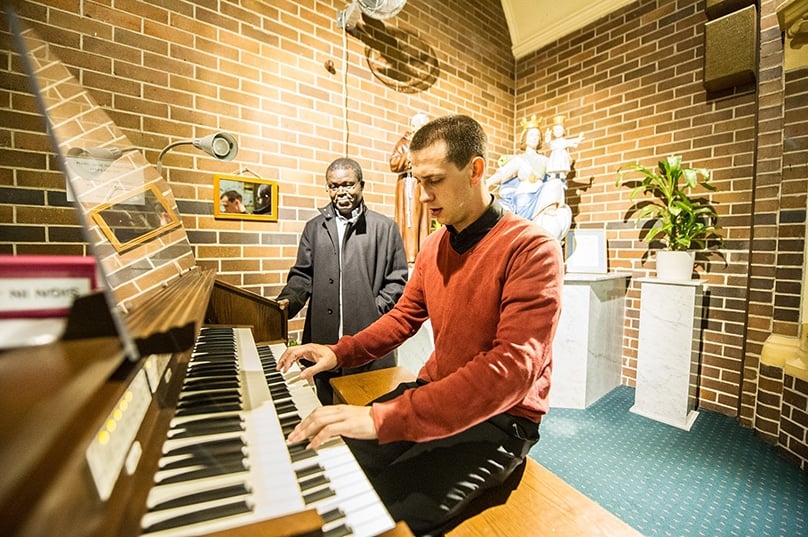 Fr Benjamin Gandy plays the organ at Our Lady of the Holy Rosary Parish in Fairfield. Photo: Supplied