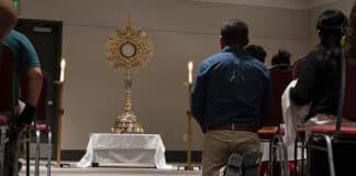 A man kneels before a large monstrance containing the Blessed Sacrament during the Diocese of Salt Lake City's Eucharistic Rally and Mass on 9 July 2023, at the Mountain America Expo Center in Sandy, Utah. Photo: OSV news photo/Sam Lucero photo