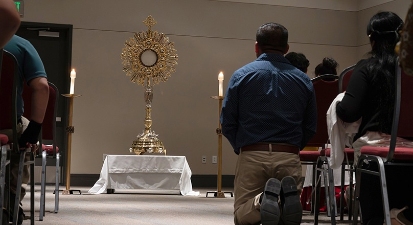 A man kneels before a large monstrance containing the Blessed Sacrament during the Diocese of Salt Lake City's Eucharistic Rally and Mass on 9 July 2023, at the Mountain America Expo Center in Sandy, Utah. Photo: OSV news photo/Sam Lucero photo