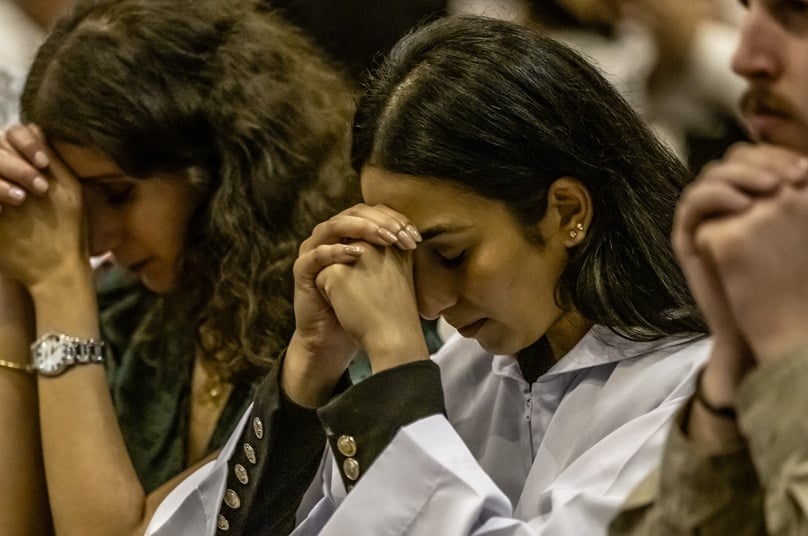A newly-received Catholic prays during the Easter Vigil Mass at St Mary's Cathedral on 31 March. Photo: Giovanni Portelli