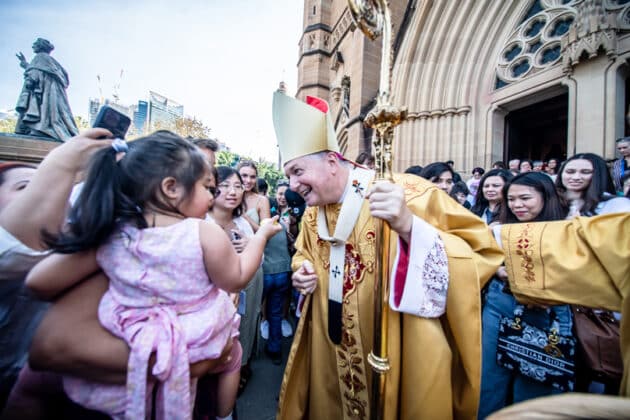 Archbishop Anthony Fisher OP greets the faithful outside of St Mary's Cathedral on Easter Sunday morning. Photo: Giovanni Portelli